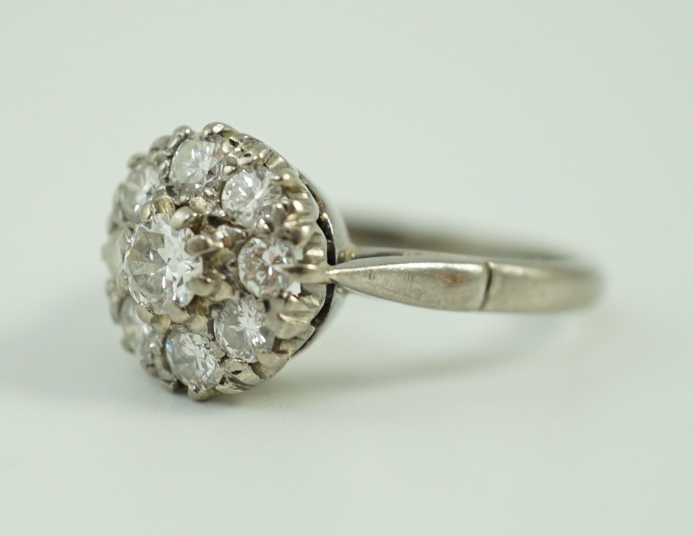 An 18ct white gold and nine stone diamond flower head cluster ring